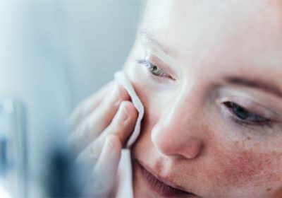 Woman removing make up in bathroom.